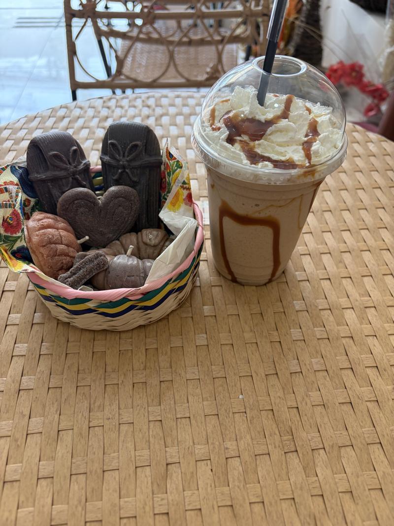 Canasta con velas de pan dulce de chocolate junto a un frappé
